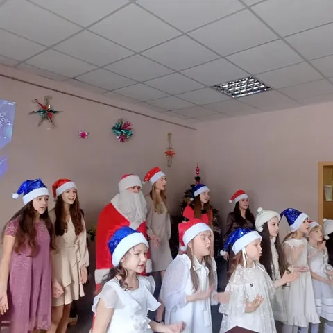 Хор в новогодних колпаках и Дед Мороз