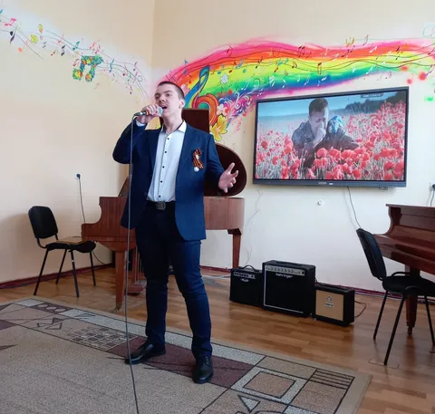 Солист поёт, на экране — маковое поле